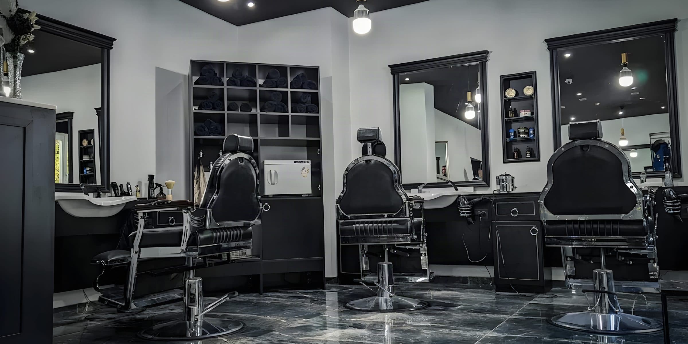 Salon mit drei Friseurstühlen vor großen Spiegeln, dunkler Marmorboden
